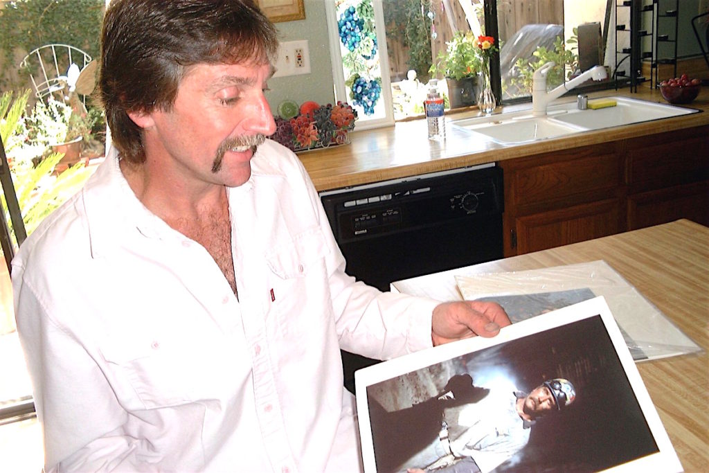 Ironworker Paul Pursley at his Escondido apartment looks at Joel Meyerowitz's iconic photo of himself at Ground zero. The photo served as the cover shot for Meyerowitz's famous exhibit of his Ground Zero work./Dan Weisman